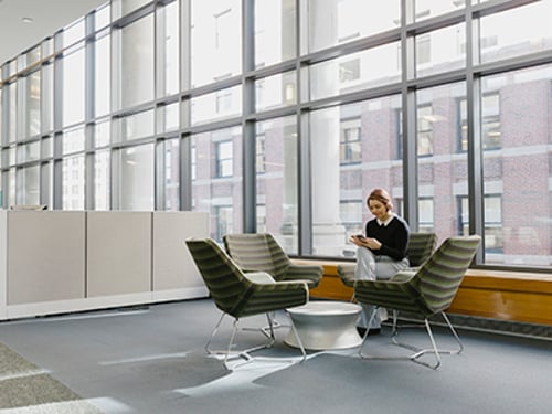 Team sitting around table doing work on laptops and smartphones using a Vonage integration